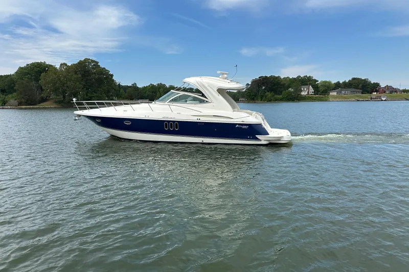 Slide: The Image of 2005 Cruisers Yachts 400 Express on calm water, surrounded by greenery. - 3