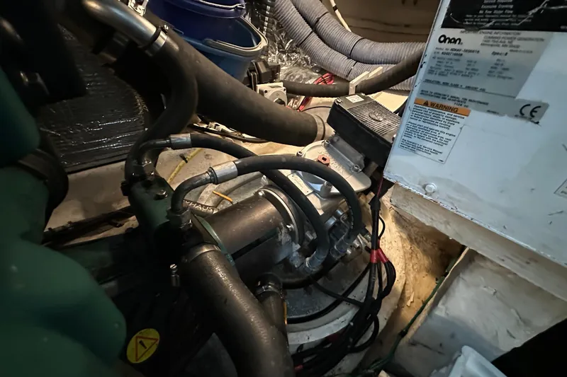 Slide: The Image of Engine compartment of a 2005 Cruisers Yachts 400 Express with visible hoses and machinery. - 34