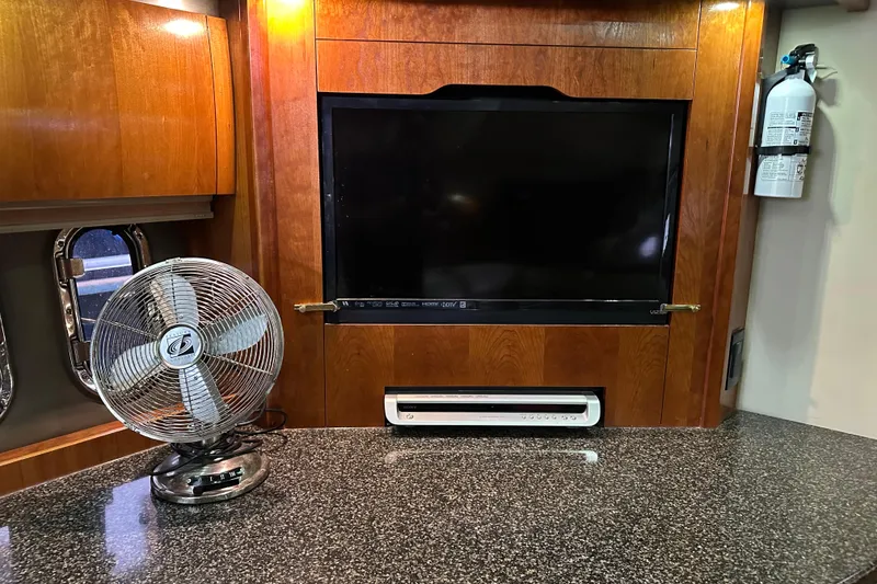 Slide: The Image of 2005 Cruisers Yachts 400 Express interior with TV, fan, and fire extinguisher. - 39