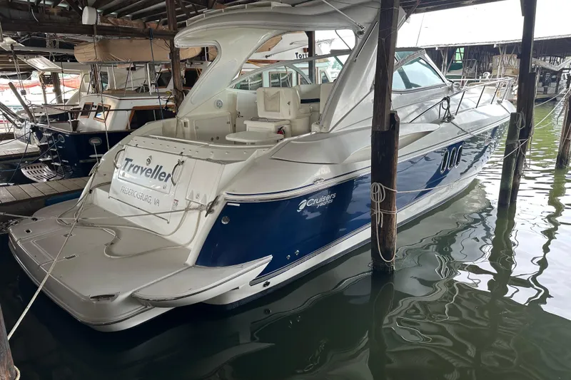Slide: The Image of 2005 Cruisers Yachts 400 Express docked in a marina, featuring sleek design and blue accents. - 4