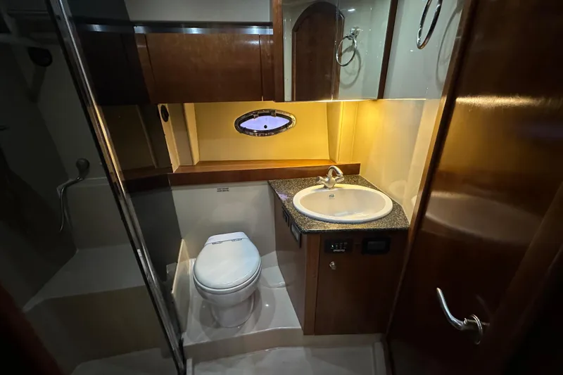 Slide: The Image of Luxurious bathroom in 2005 Cruisers Yachts 400 Express with modern fixtures and wood accents. - 48
