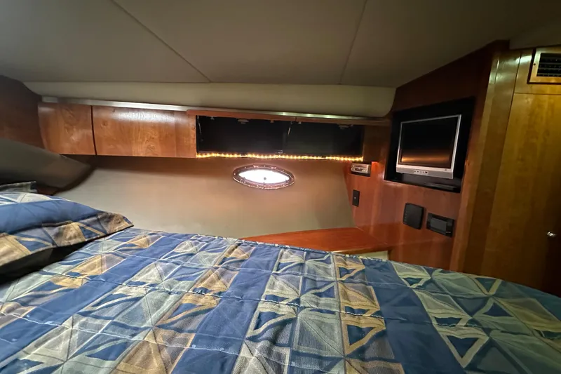 Slide: The Image of Luxurious cabin interior of 2005 Cruisers Yachts 400 Express with cozy bedding and TV. - 51