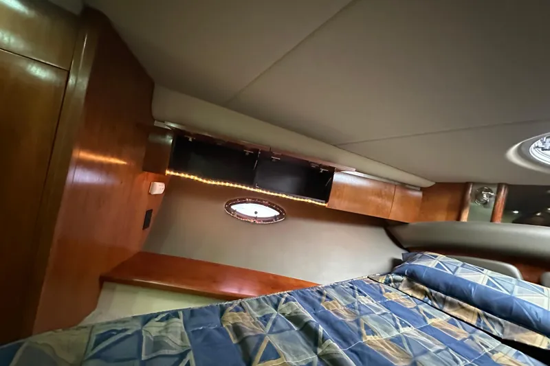 Slide: The Image of Interior cabin of 2005 Cruisers Yachts 400 Express with wood paneling and patterned bedding. - 52