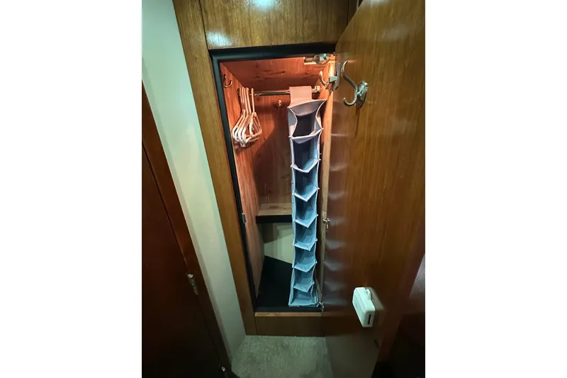 Slide: The Image of Wooden closet interior with hangers and fabric organizer in 2005 Cruisers Yachts 400 Express. - 55