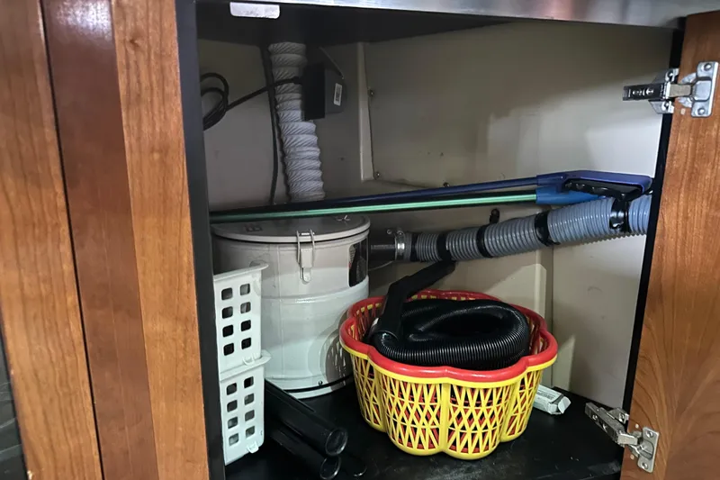 Slide: The Image of Storage compartment in a 2005 Cruisers Yachts 400 Express with cleaning supplies and hoses. - 57
