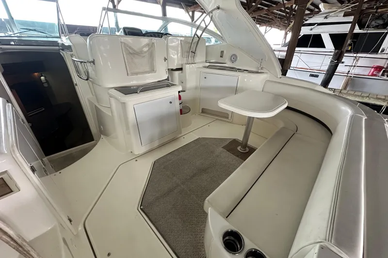 Slide: The Image of 2005 Cruisers Yachts 400 Express interior with seating and table in a covered dock. - 8