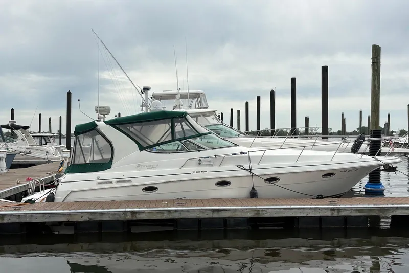 The Image of 1999 Cruisers Yachts 3375 Esprit docked at marina under cloudy sky. - 0