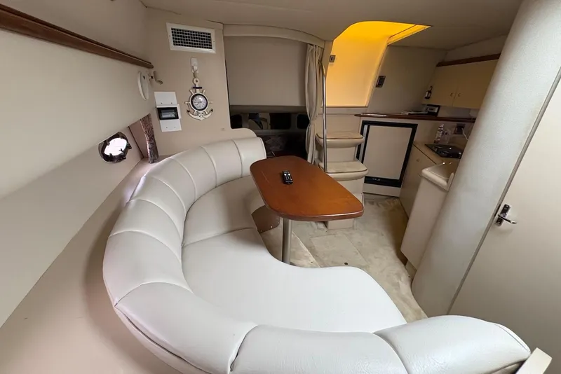 Slide: The Image of 1999 Cruisers Yachts 3375 Esprit interior with white seating and wooden table. - 10