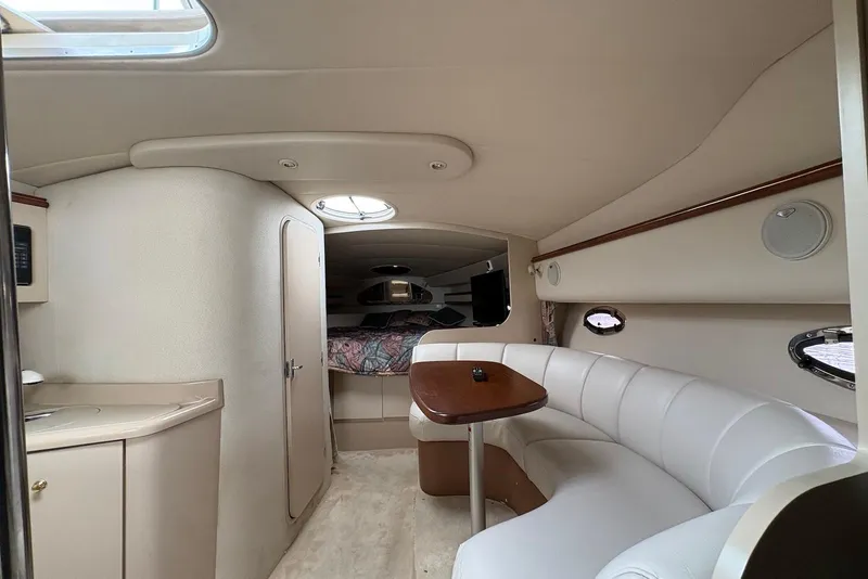 Slide: The Image of 1999 Cruisers Yachts 3375 Esprit interior with white seating and wooden table. - 11