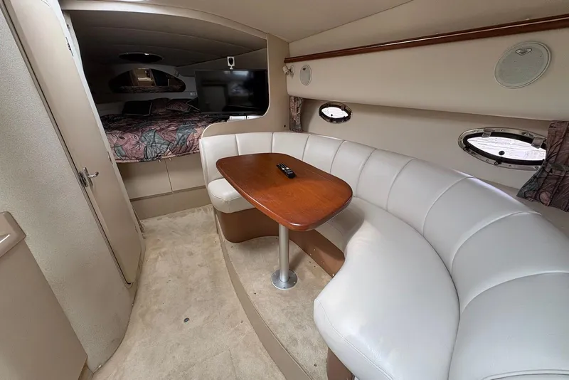 Slide: The Image of 1999 Cruisers Yachts 3375 Esprit interior with curved seating and wooden table. - 12