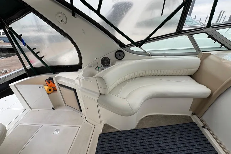 Slide: The Image of 1999 Cruisers Yachts 3375 Esprit interior with white seating and compact kitchenette. - 8