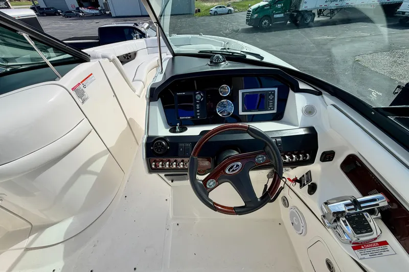 Slide: The Image of Cockpit view of 2008 Sea Ray 300 SLX boat with steering wheel and navigation controls. - 10