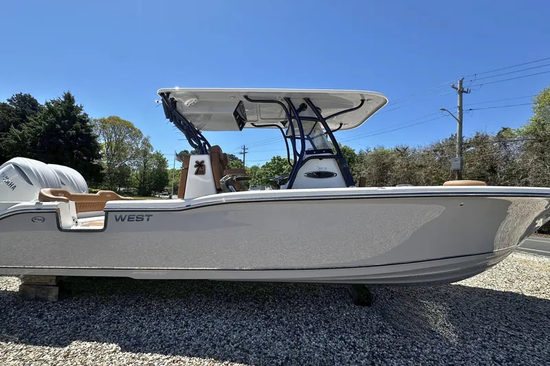 The Image of 2026 Key West 291 FS boat with T-top, parked on gravel under clear blue sky. - 0