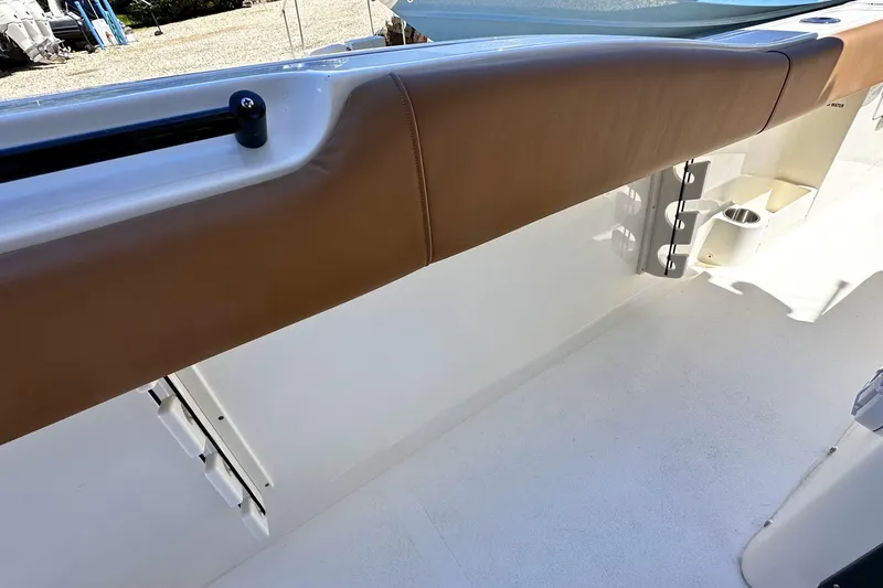 Slide: The Image of 2026 Key West 291 FS boat interior with brown cushioned seating and white deck. - 10