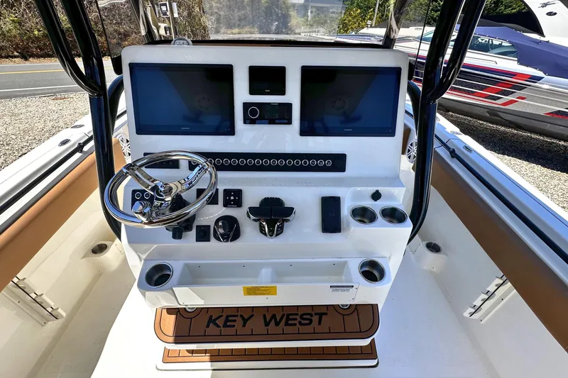 Slide: The Image of 2026 Key West 291 FS boat dashboard with dual screens and steering wheel. - 13