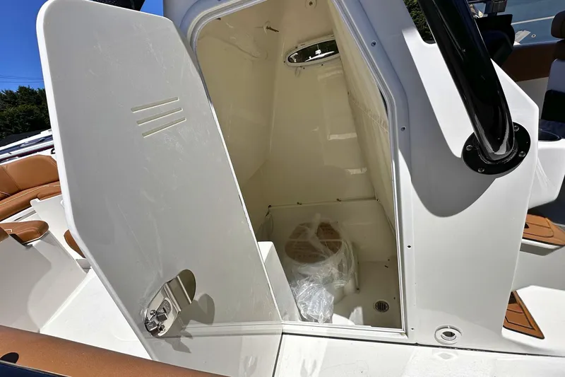 Slide: The Image of 2026 Key West 291 FS boat interior cabin with open door, showcasing seating and storage. - 15