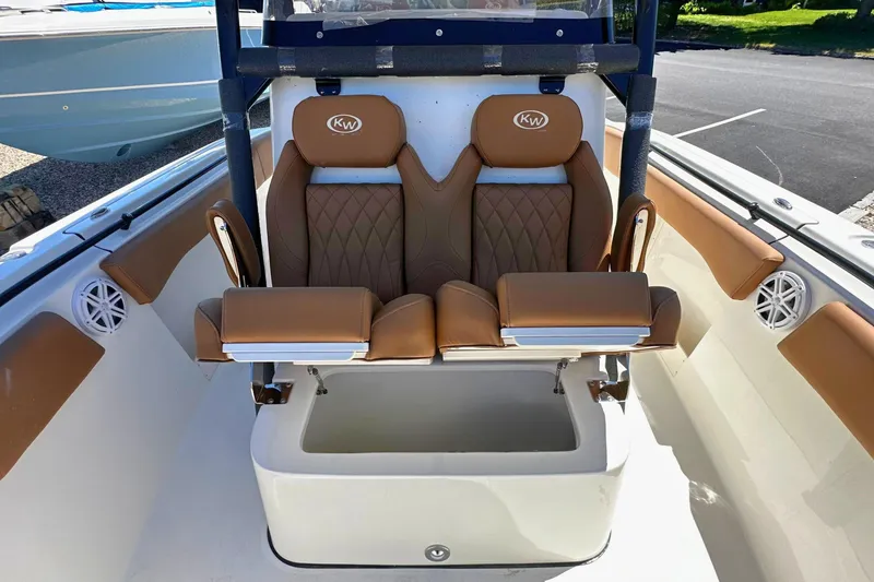 Slide: The Image of 2026 Key West 291 FS boat interior with tan cushioned seats and storage compartment. - 17