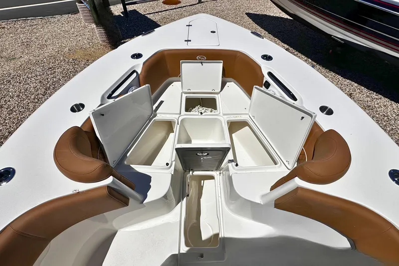 Slide: The Image of 2026 Key West 291 FS boat interior with open storage compartments and brown seating. - 19