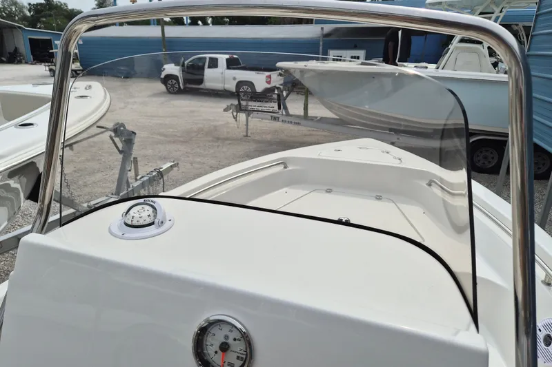 Slide: The Image of 2026 Key West 189 FS boat interior with compass and windshield, parked in a marina. - 12