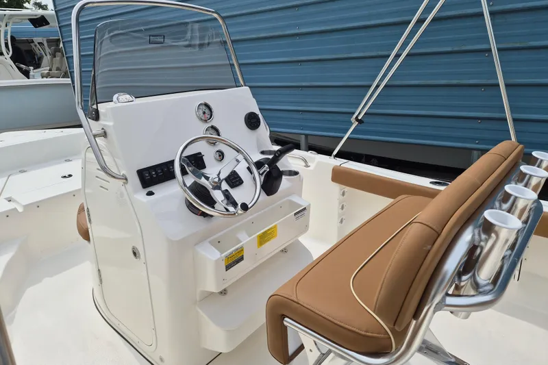 Slide: The Image of 2026 Key West 189 FS boat interior with steering console and tan seating. - 6