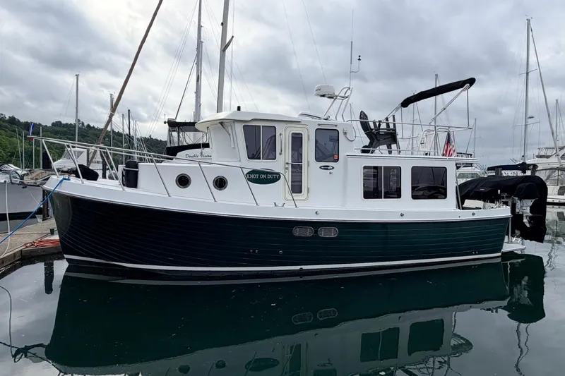 The Image of American Tug 34, 2002 model, docked at marina with overcast sky. - 0