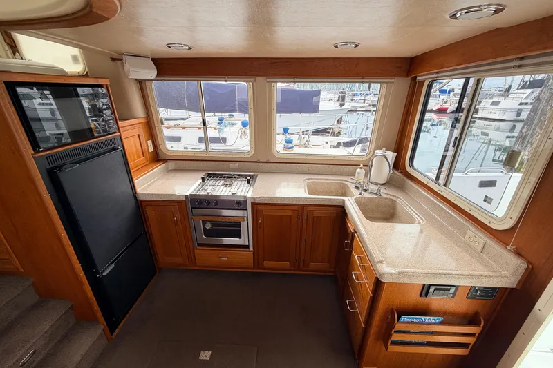 Slide: The Image of Interior of 2002 American Tug 34 kitchen with stove, sink, and large windows. - 10