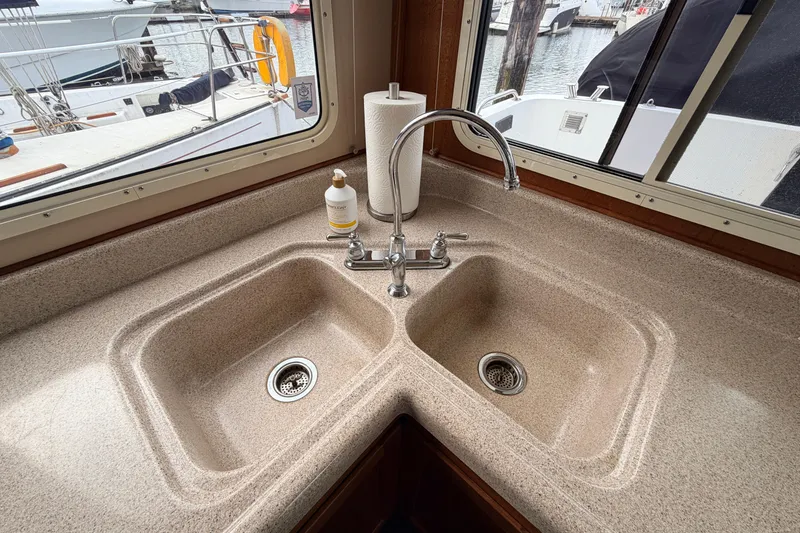 Slide: The Image of Dual sink in 2002 American Tug 34 boat kitchen with marina view. - 14