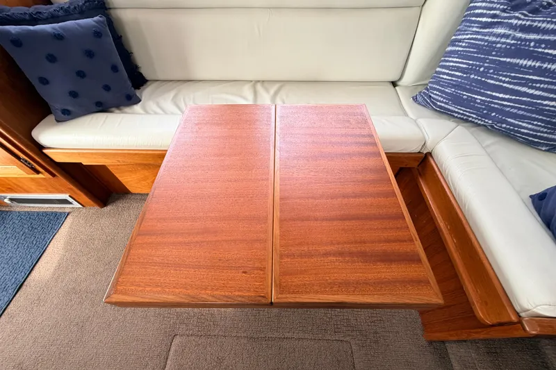 Slide: The Image of Interior of a 2002 American Tug 34 with a wooden table and cushioned seating. - 17
