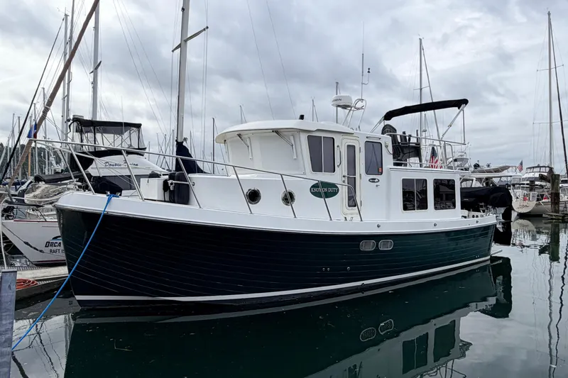 Slide: The Image of 2002 American Tug 34 boat docked in a marina, overcast sky. - 2