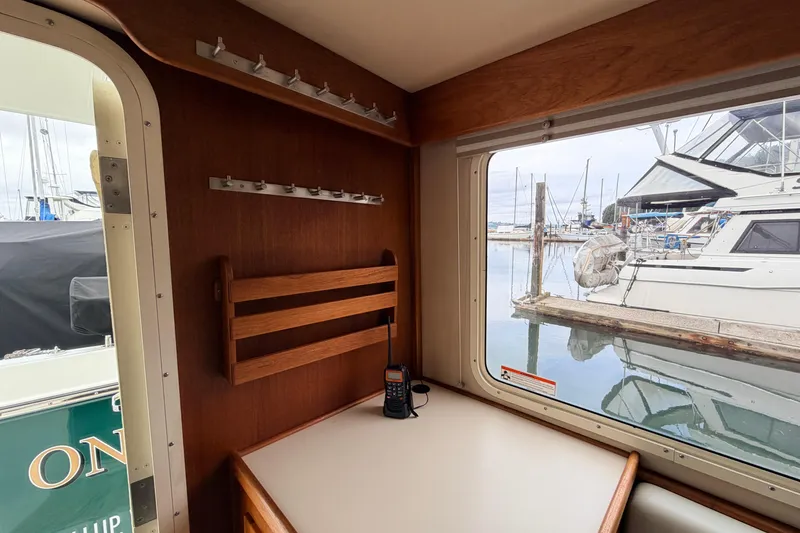 Slide: The Image of Interior view of a 2002 American Tug 34, featuring a window overlooking a marina. - 22