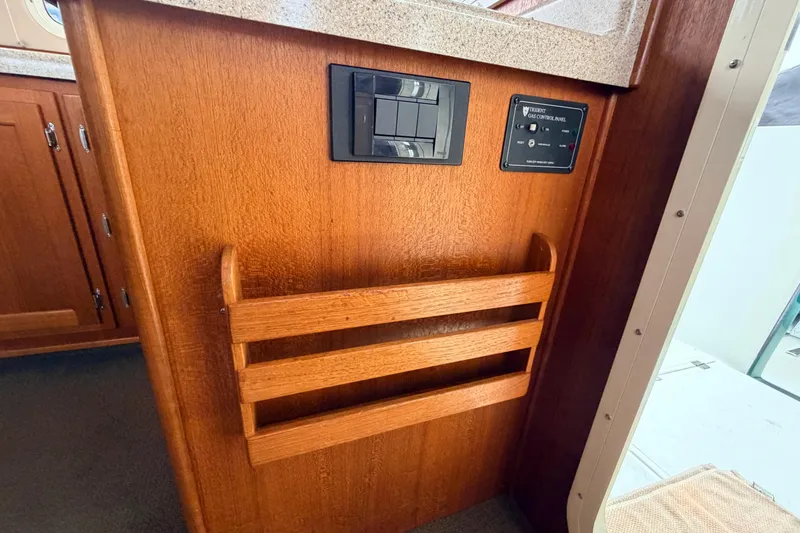 Slide: The Image of Interior of 2002 American Tug 34, featuring wooden cabinetry and control panels. - 23