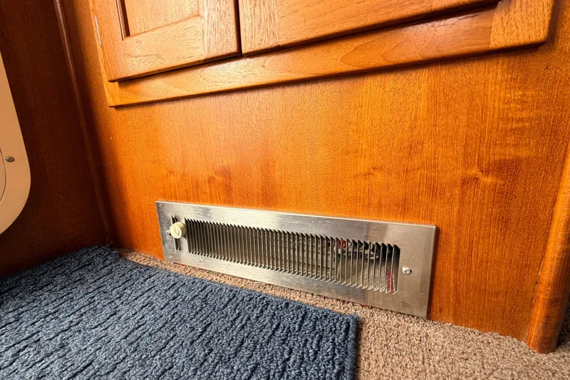 Slide: The Image of Wooden interior of 2002 American Tug 34 with metal vent and carpeted floor. - 24