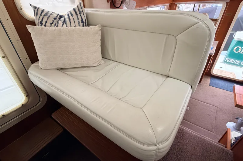 Slide: The Image of Cream leather seating with decorative pillows inside a 2002 American Tug 34 boat. - 29