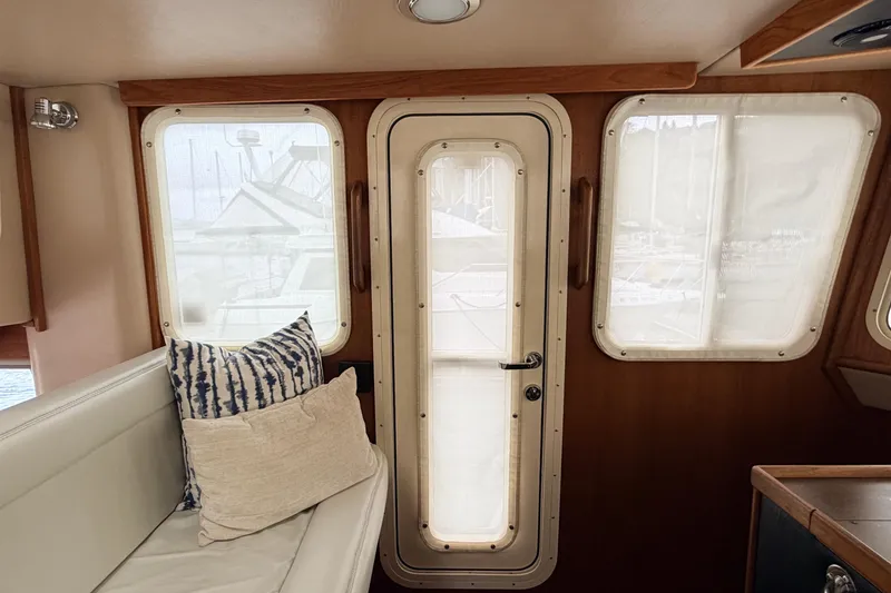 Slide: The Image of Interior of 2002 American Tug 34 with cushioned seating and nautical decor. - 31