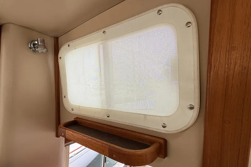 Slide: The Image of Interior window of 2002 American Tug 34 with wooden trim and light fixture. - 34