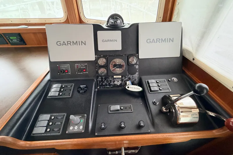 Slide: The Image of American Tug 34 helm with Garmin navigation, throttle controls, and instrument panel, 2002 model. - 35
