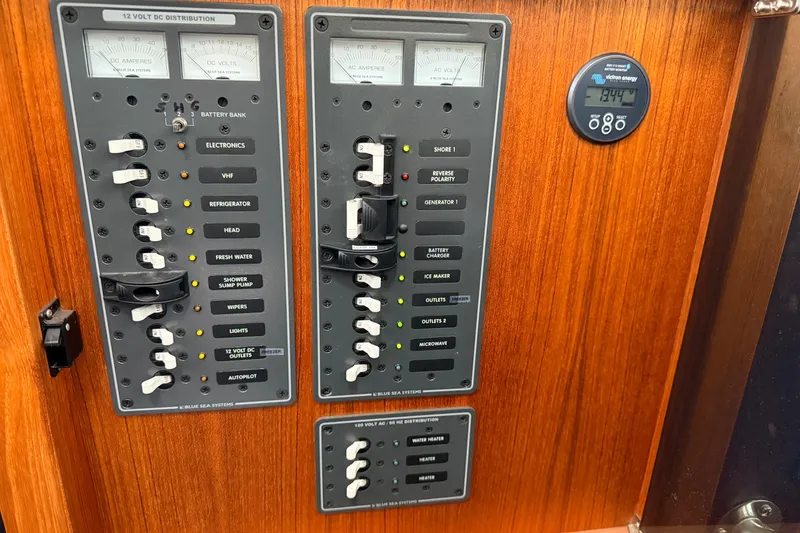 Slide: The Image of Electrical control panel on a 2002 American Tug 34 boat, featuring various switches and gauges. - 45
