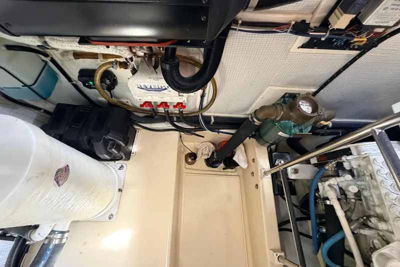 Slide: The Image of Engine room of a 2002 American Tug 34, showcasing mechanical components and wiring. - 49