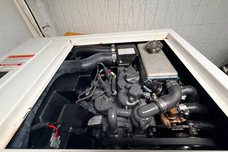 Slide: The Image of Engine compartment of a 2002 American Tug 34, showcasing mechanical components and hoses. - 60