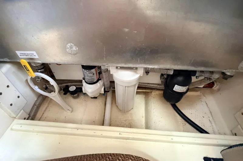 Slide: The Image of Engine compartment of a 2002 American Tug 34, showing plumbing and filtration system. - 63