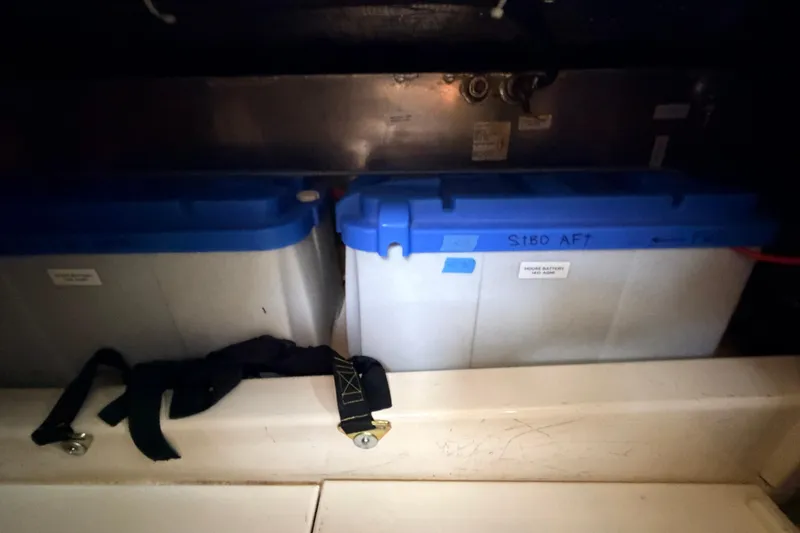 Slide: The Image of Battery compartment in a 2002 American Tug 34 boat with secured blue-lidded batteries. - 65