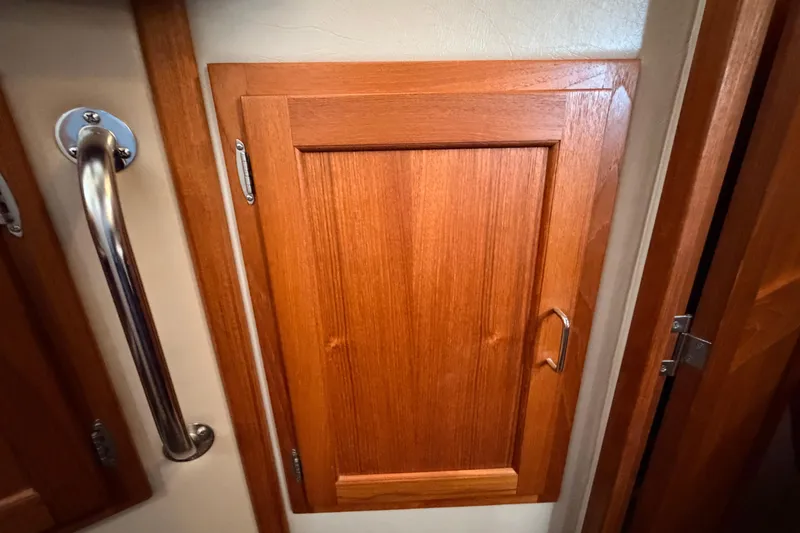 Slide: The Image of Wooden cabinet door with metal handle inside a 2002 American Tug 34 boat. - 67
