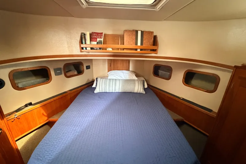Slide: The Image of Cozy cabin interior of 2002 American Tug 34 with blue bedding and wooden accents. - 68