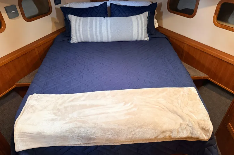 Slide: The Image of Cozy cabin bed in 2002 American Tug 34 with blue bedding and soft pillows. - 69