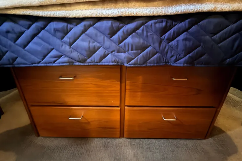 Slide: The Image of Wooden drawers under a quilted bed cover in a 2002 American Tug 34 boat. - 70