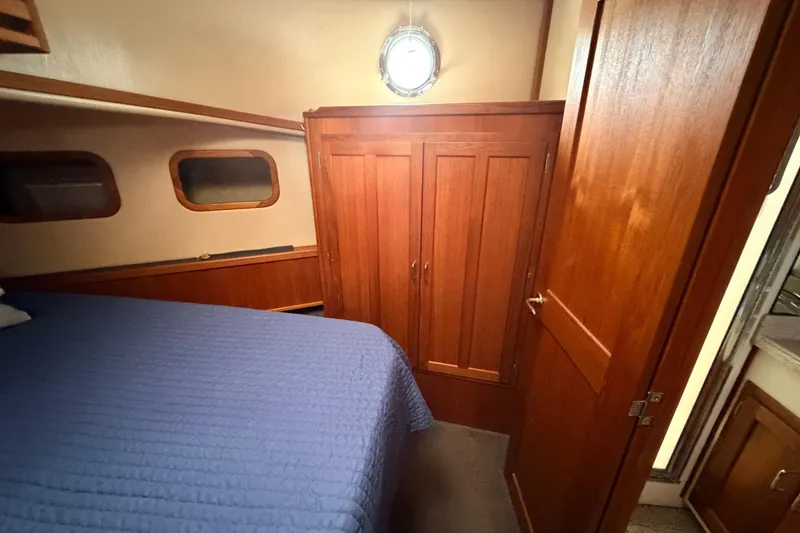 Slide: The Image of Cozy cabin interior of 2002 American Tug 34 with wooden wardrobe and blue bedding. - 71