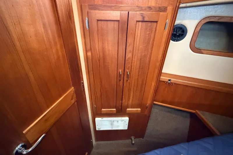 Slide: The Image of Interior of 2002 American Tug 34, featuring wooden cabinetry and a small vent. - 73