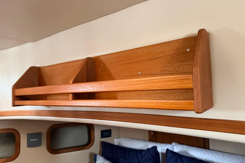 Slide: The Image of Wooden shelf in 2002 American Tug 34 cabin interior, above blue-cushioned seating. - 74