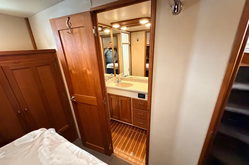 Slide: The Image of Interior of 2002 American Tug 34, featuring wooden cabinetry and a compact bathroom. - 76