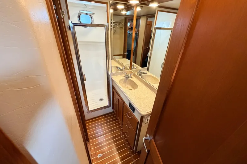 Slide: The Image of Bathroom interior of 2002 American Tug 34 with shower, sink, and wooden cabinetry. - 77